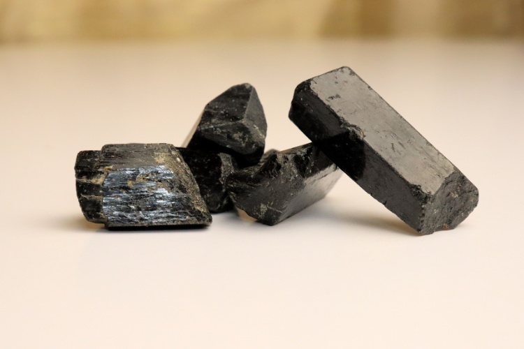 Foto de cristais de turmalina negra sobre mesa bege