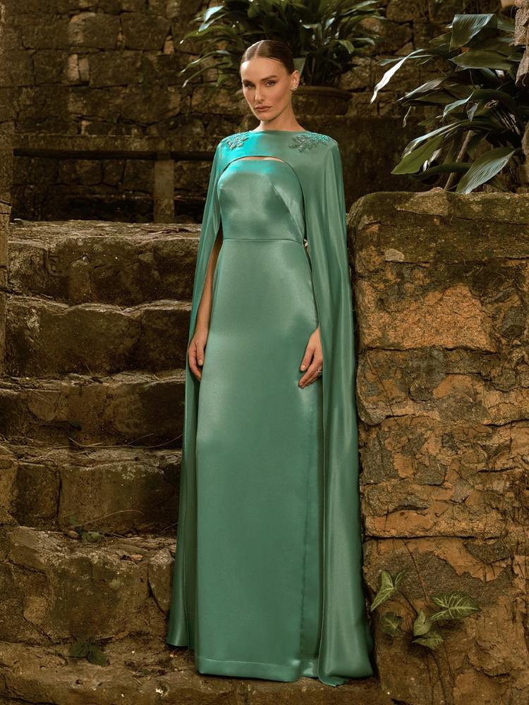 Mulher de pele clara com vestido minimalista verde menta e capa da mesma cor e tecido 
