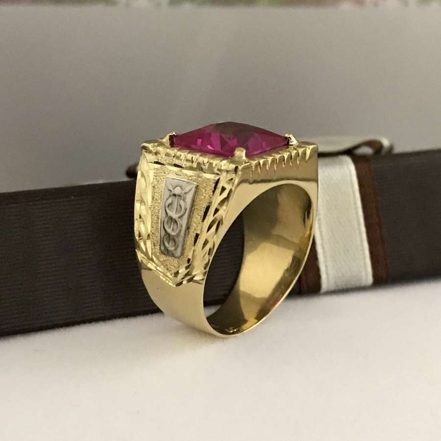 Anel dourado masculino com detalhe prateado e pedra vermelha