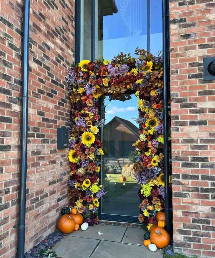 Decoração de porta de vidro para Halloween com flores coloridas e abóboras