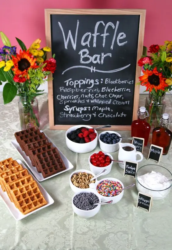 Brunch de Dia das Mães - decoração com frutas, chocolates, granulado, açúcar, geleia, waffles, flores e quadro negro