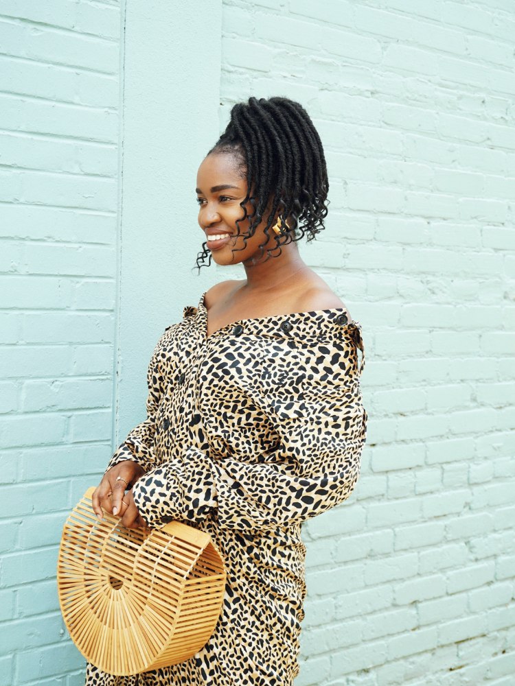 Mulher usando vestido e bolsa sorrindo para post sobre legendas para fotos sorrindo