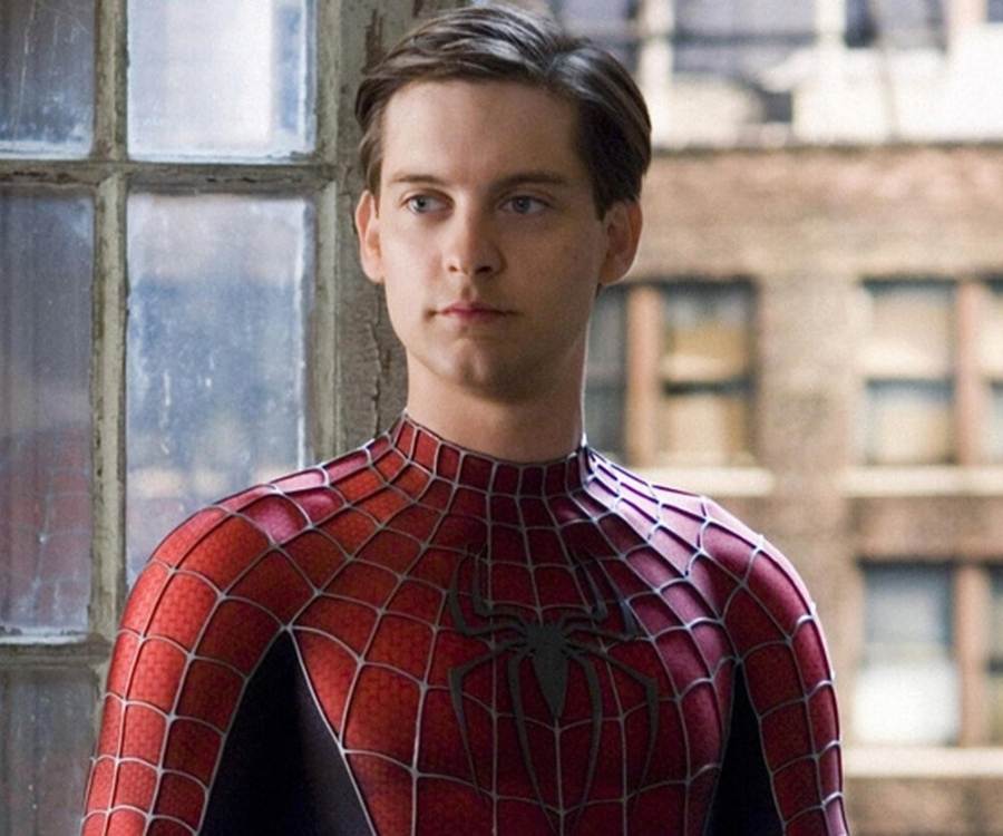 Ator Tobey Maguire em cena como Homem-Aranha. Ele está sem máscara, usando traje do personagem e possivelmente de frente a janela de um prédio., do lado de dentro 