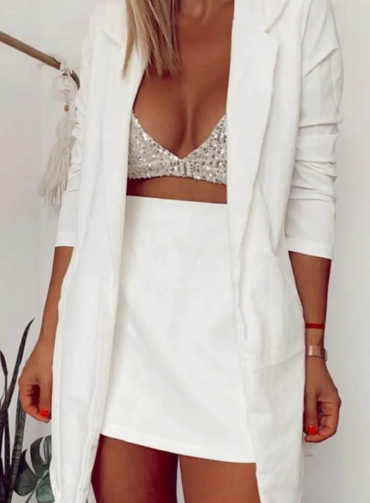Mulher com conjunto branco e top brilhante
