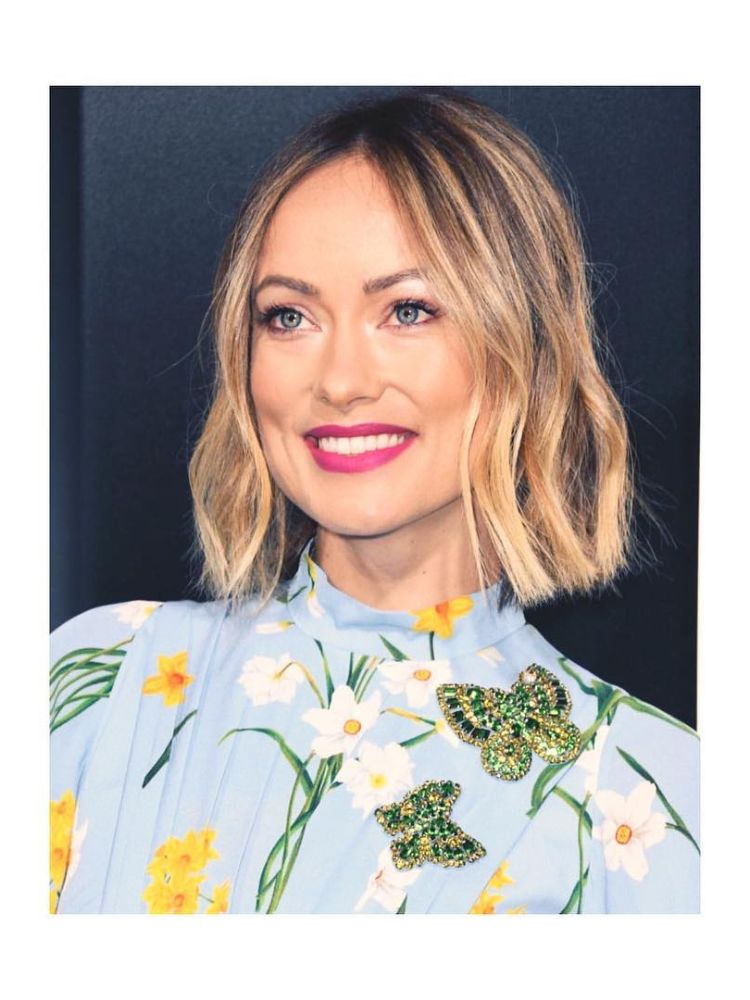 Olivia Wilde de camisa azul com flores e cabelo loiro chanel 