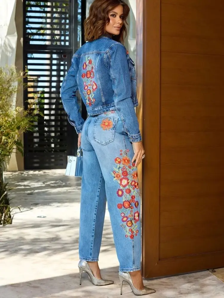 Mulher de pele clara usando jaqueta e calça jeans com bordados florais 