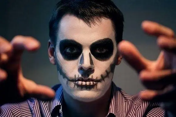 Foto de homem de pele clara com maquiagem de caveira