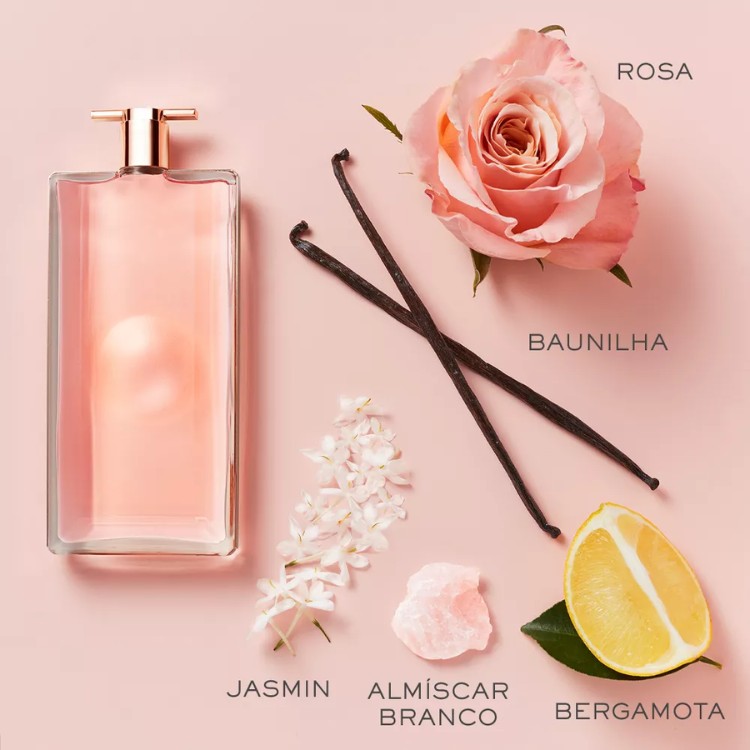 Frasco grande do Idôle em fundo rosa com ingredientes da fragrância, como rosa e bergamota
