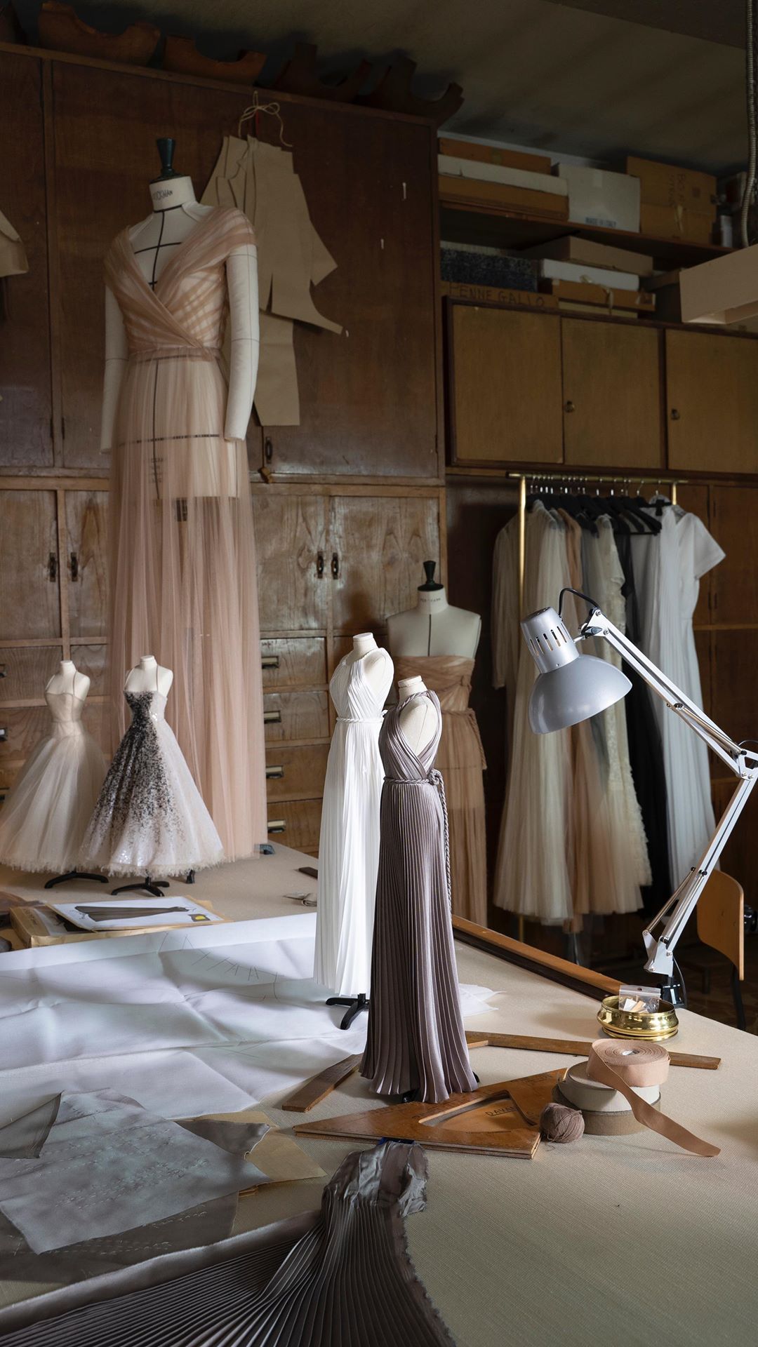 Imagem de um estúdio com manequins em tamanho real e miniatura vestidos como deusas gregas. 