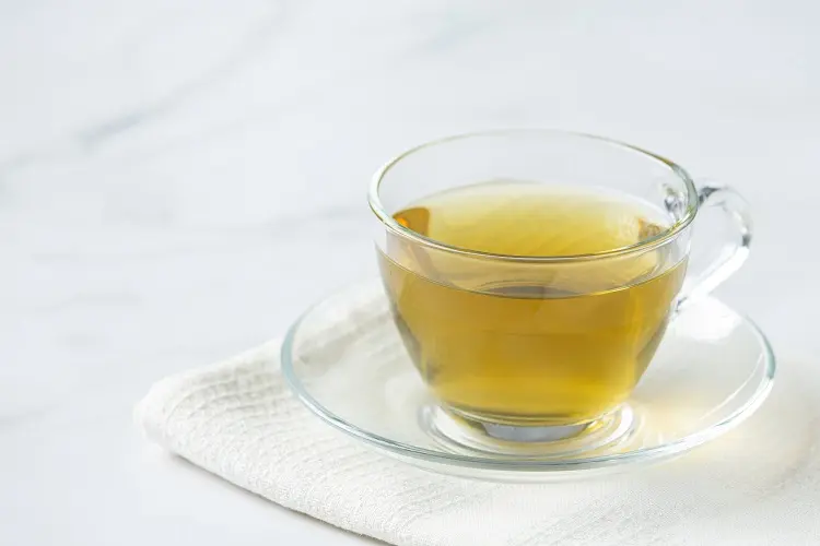 Foto de infusão de cavalinha em xícara de vidro