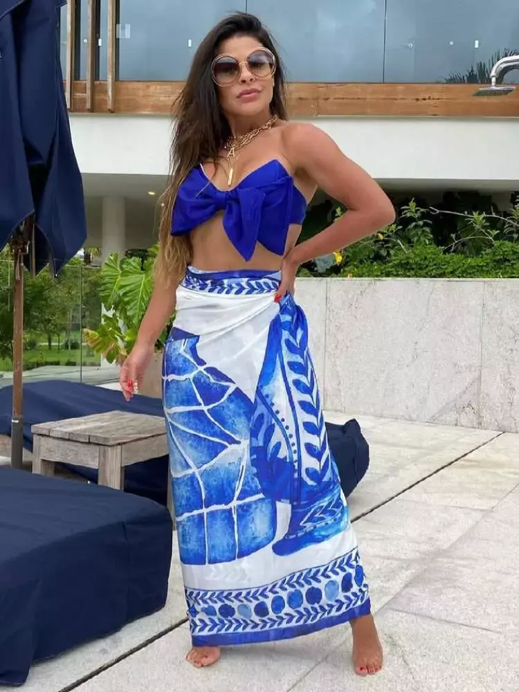 Mulher veste top de biquíni e canga como sugestão de roupa para ano novo na praia