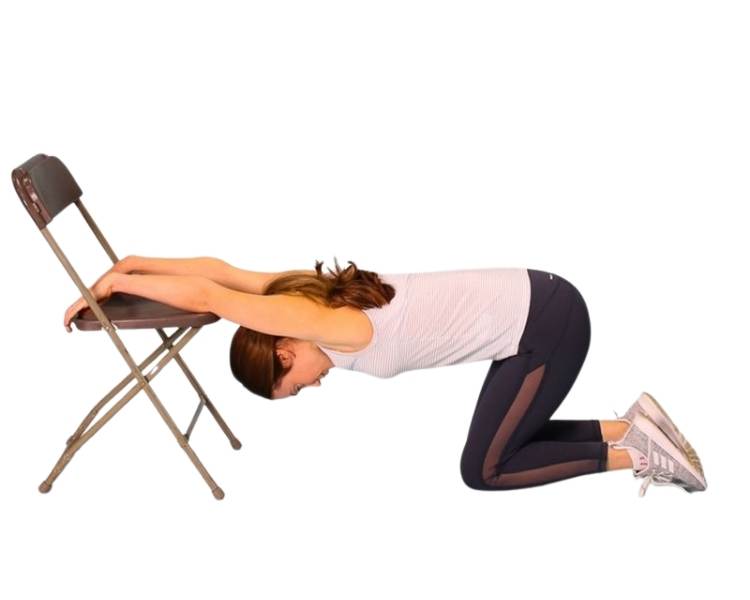 mulher fazendo alongamento do grande dorsal com cadeira. Foto mulher fazendo exercício grande dorsal com cadeira.
