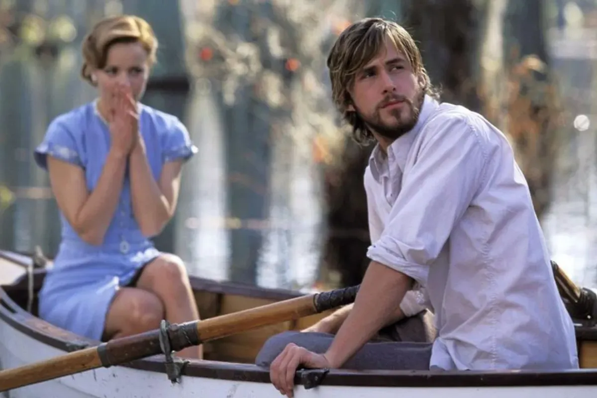 Casal sentado em um pequeno barco em um lago tranquilo, em uma cena romântica de filme com clima emocional e natureza ao redor