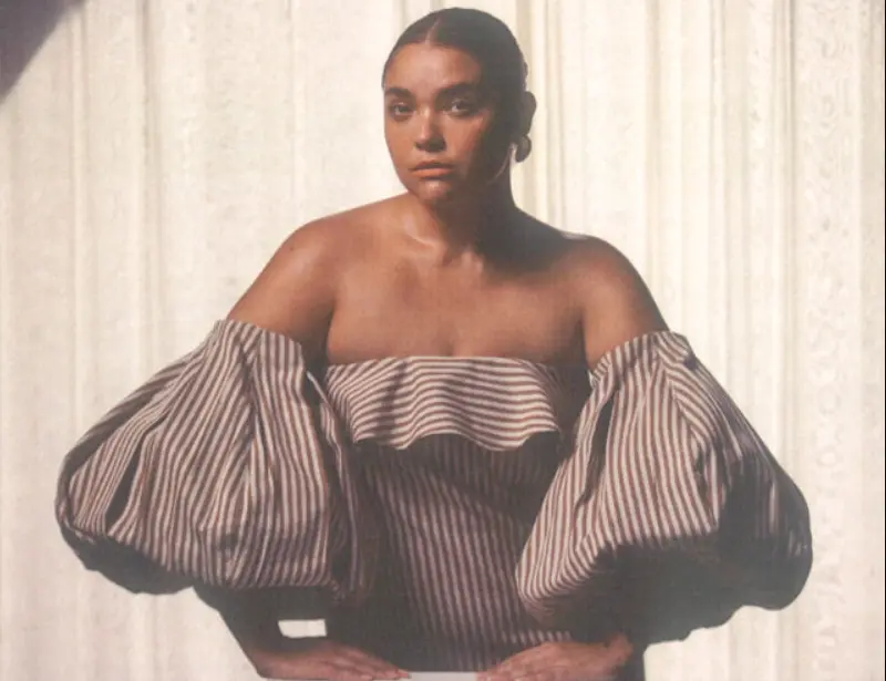 Modelo utiliza vestido com decote ciganinha e mangas extra bufantes listrado