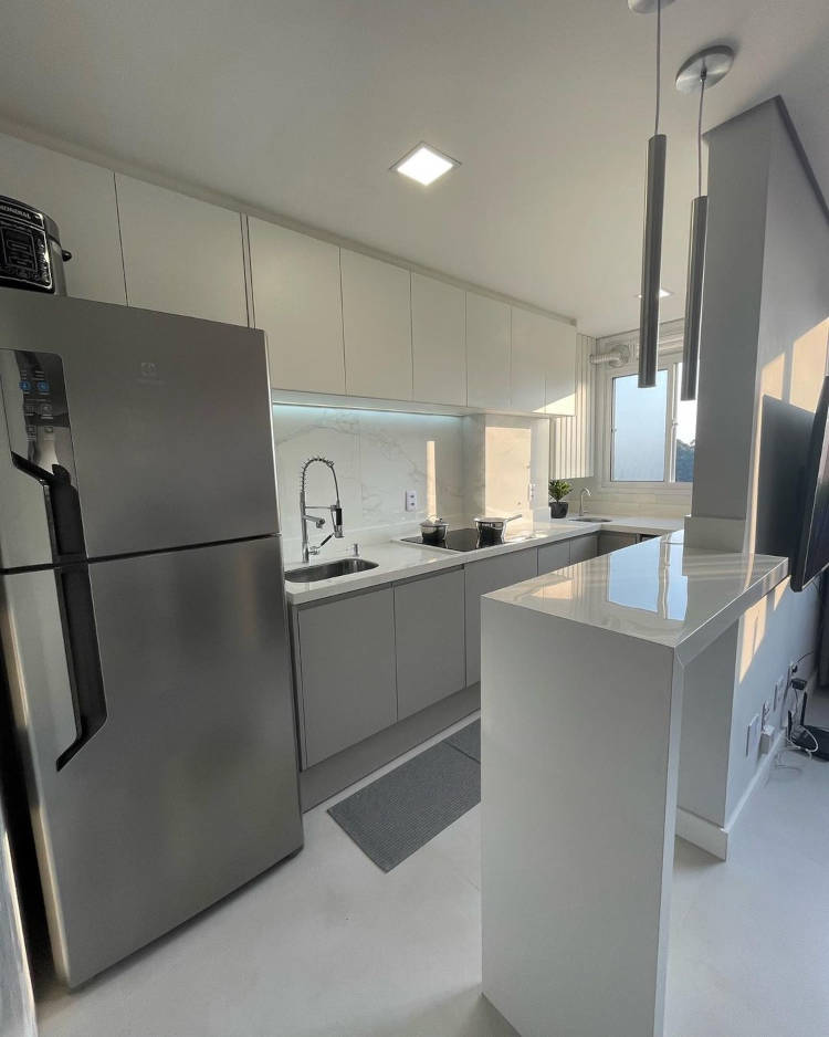 Cozinha de apartamento com porcelanato na bancada.