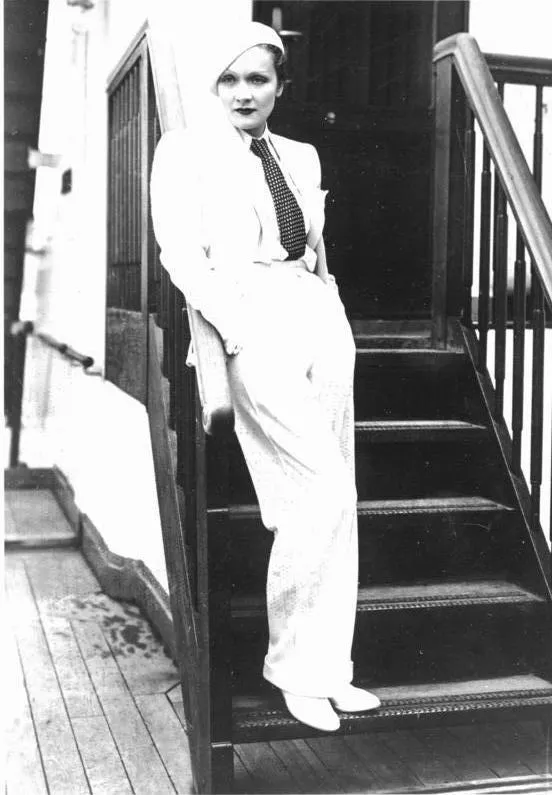 A atriz Marlene Dietrich vestida com um terninho branco e fravata, em 1933. Look da Moda e Cidadania nos anos 20 e 30.
