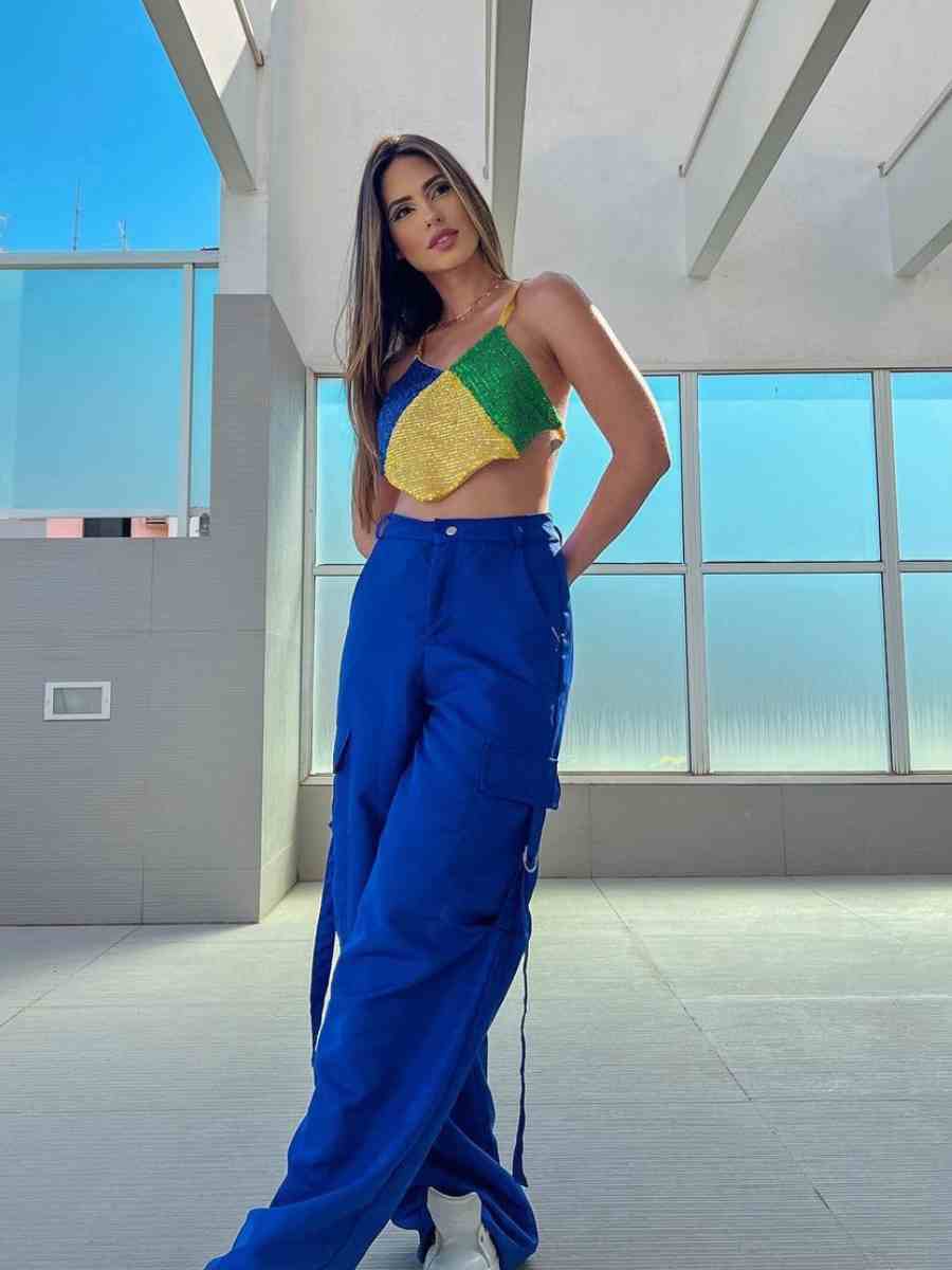 Foto de mulher usando look para a Copa: calça azul + cropped azul, amarelo e verde.