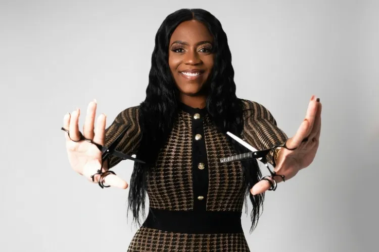 Foto de mulher negra segurando duas tesouras para cortar cabelo