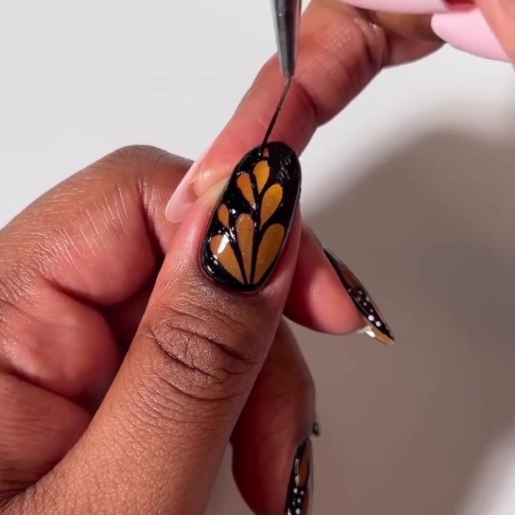 Preenchimento dos espaços entre as formas com esmalte preto, destacando o design.

