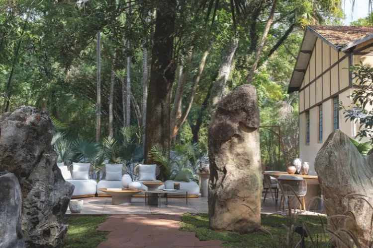 Jardim com estofado claro e círculo de pedras