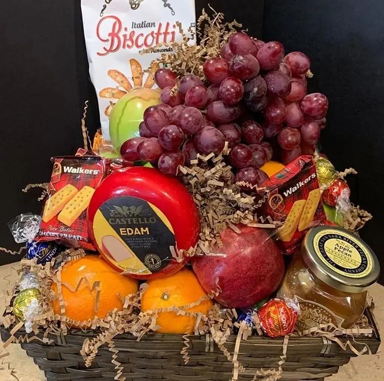 frutas frescas, queijos, biscoitos e geleias em cesta 