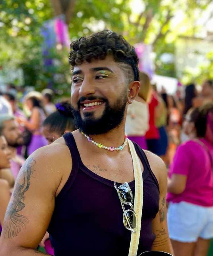 Homem de pele morena com regata preta e sombra de glitter