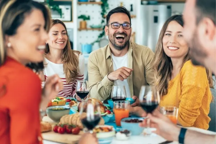 Jovens de pele clara sorrindo em almoço 