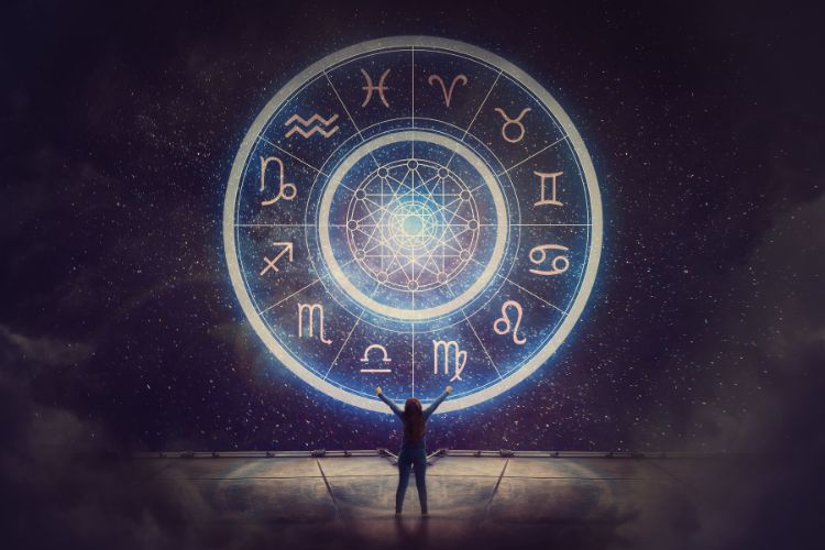 Uma figura humana contempla um grande círculo iluminado com os símbolos do zodíaco, projetado contra um céu estrelado. A cena transmite mistério, conexão cósmica e a busca por respostas no universo e na astrologia.