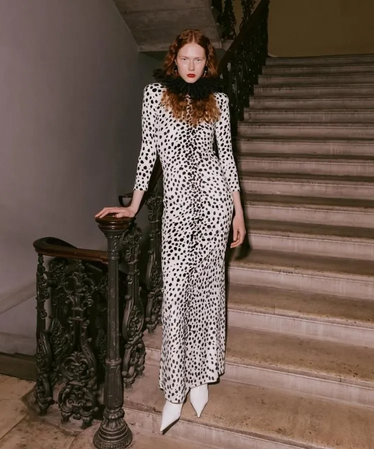 Foto de modelo usando vestido branco e preto com gola elisabetana preta, uma das tendências da London Fashion Week Outono Inverno 2026