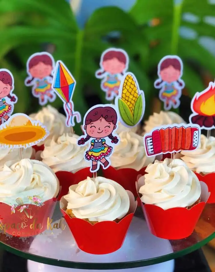 Cupcakes de chantily branco com toppers de São João: balão, milho, sanfona, chapéu de palha, fogueira, etc