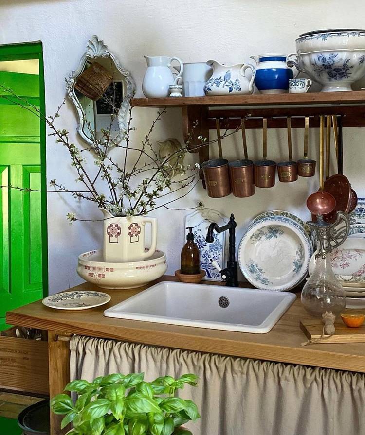 Utensílios de cozinha pendurados em decoração de cozinha estilo rural, sob pia com louças vintage