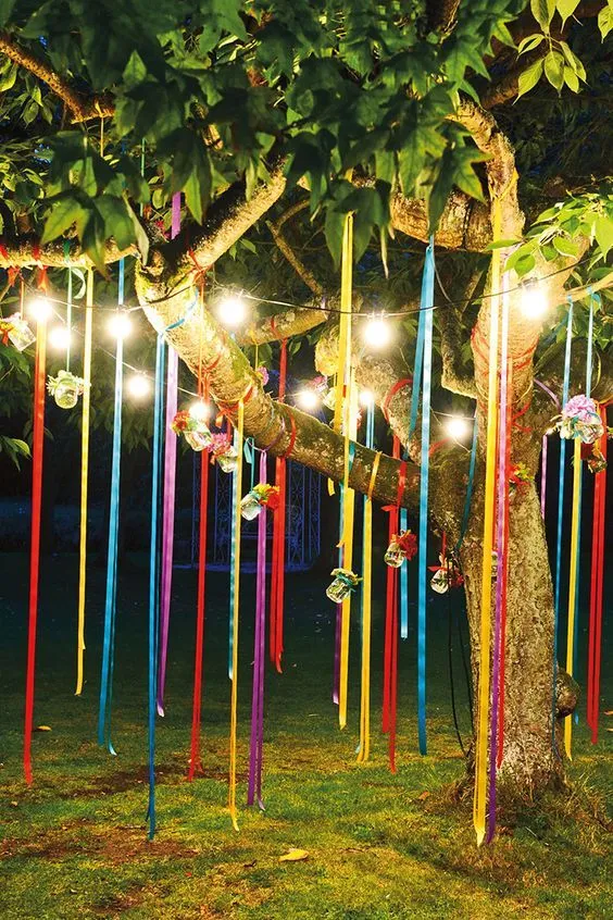 árvore decorada com fitas de cetim e luzes para festa junina