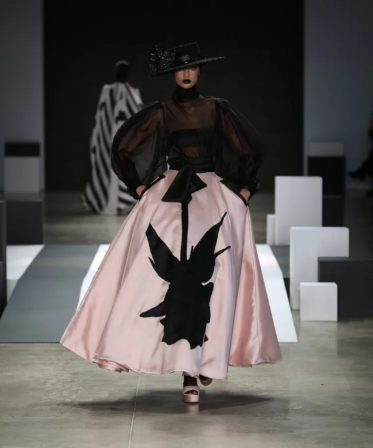 Foto de modelo usando chapéu preto e vestido com rosa negra no desfile de chapéus de Davi Ramos no SPFW N60
