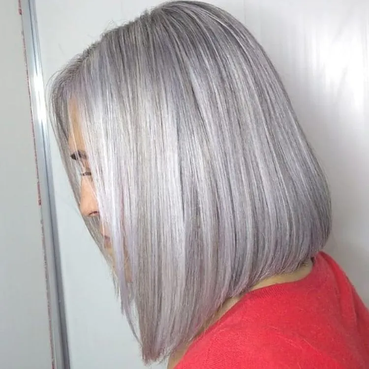 Mulher de pele clara e roupa vermelha com cabelo chanel branco