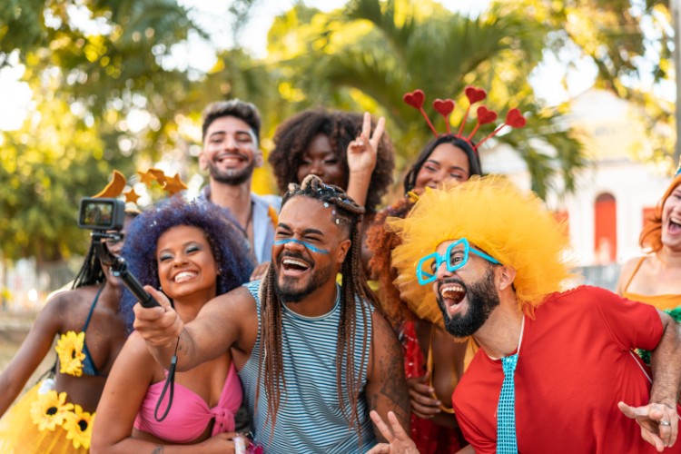 Grupo de amigos sem fantasias elaboradas curtindo o Carnaval e tirando selfie 