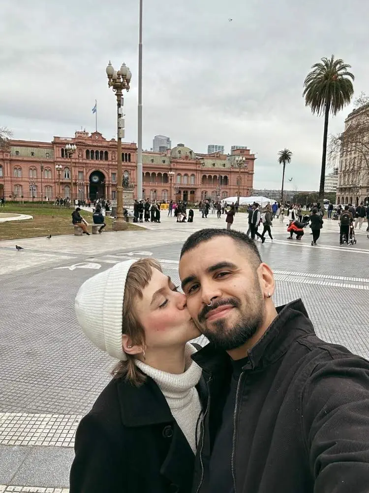 Mari Krüger com roupas de frio beijando seu noivo em Buenos Aires