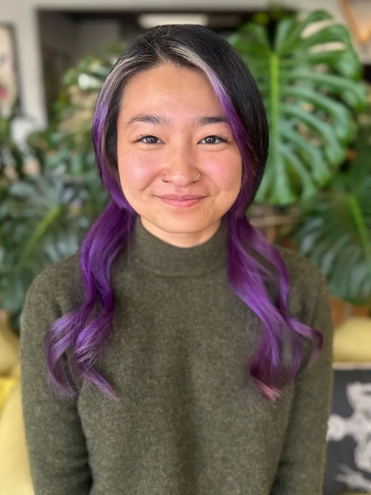 Mulher de origem ocidental usando cabelo preto e roxo em jellyfish cut 