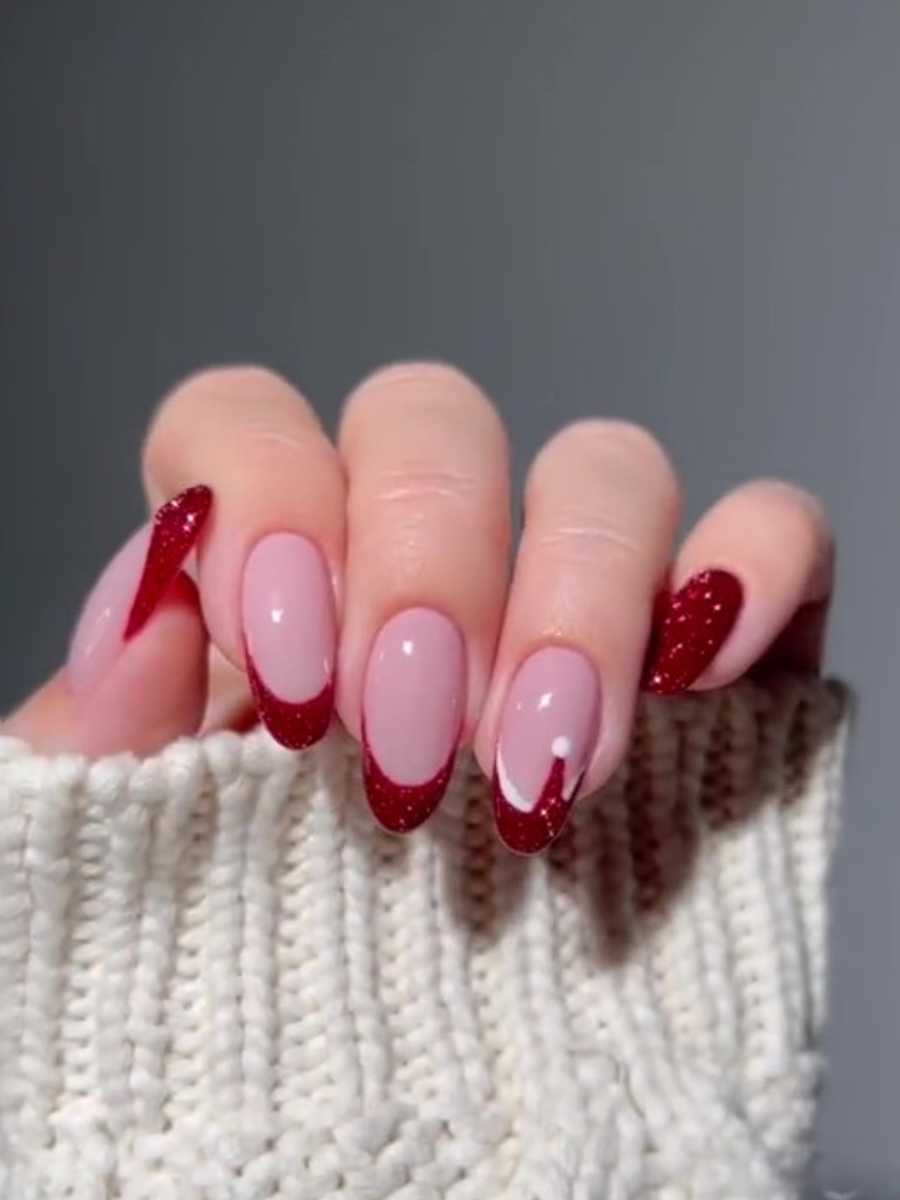 Foto de mão com unhas decoradas de Natal.