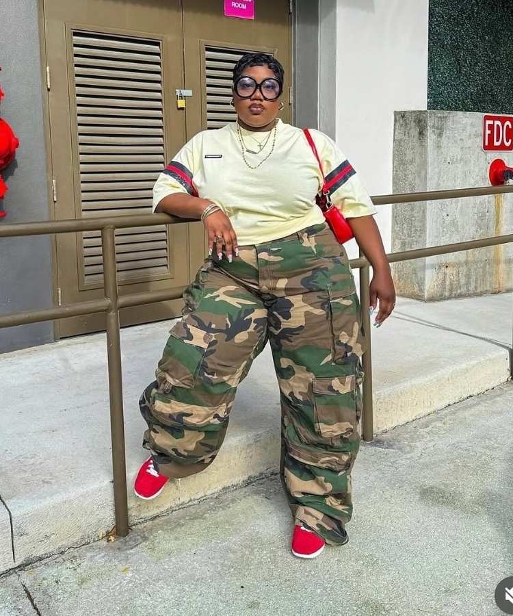 Mulher usando camiseta branca e calça com estampa camuflada