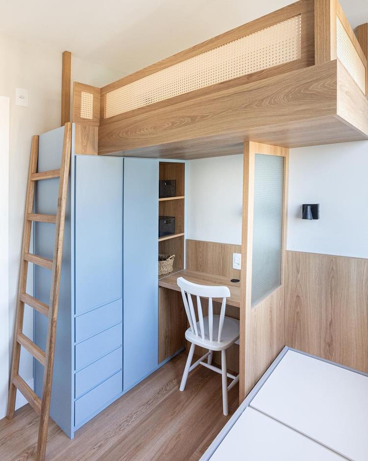 quarto de solteiro com cama de madeira suspensa, armários azuis e escrivaninha embaixo da cama 