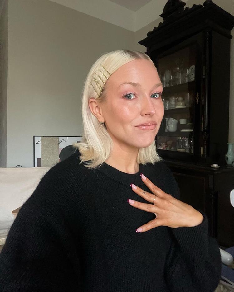 mulher de cabelo loiro curto com franja presa com grampos