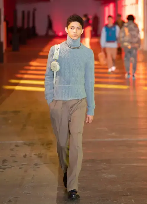 Look com blusa gola alta e recorte na barra de tricô azul na moda internacional masculina