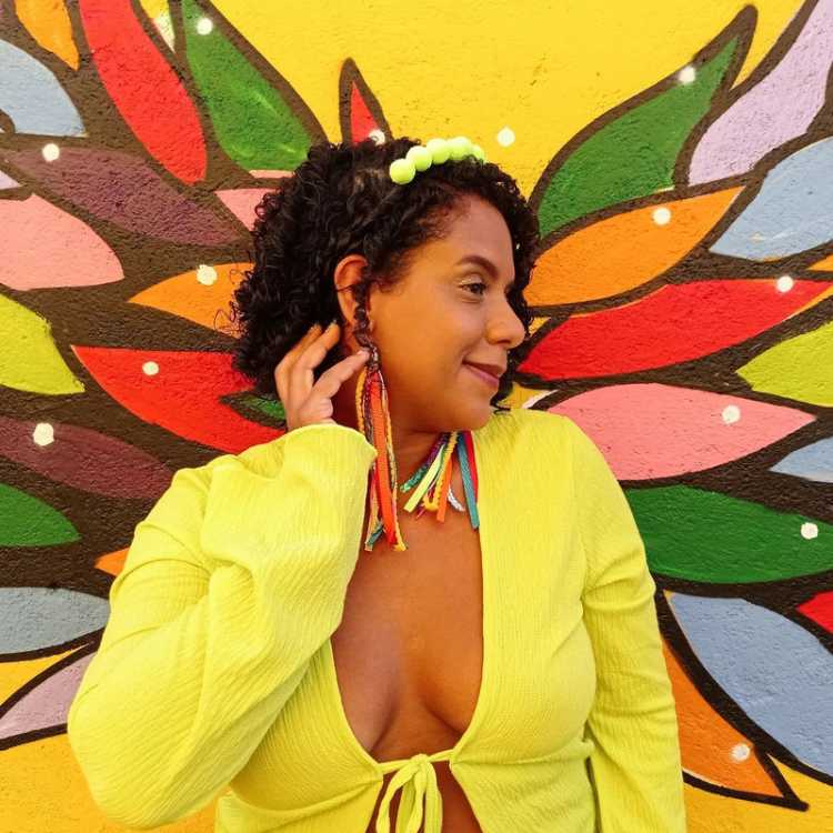 Mulher de pele negra com tiara de pompom para o Carnaval. e cropped verde-limão