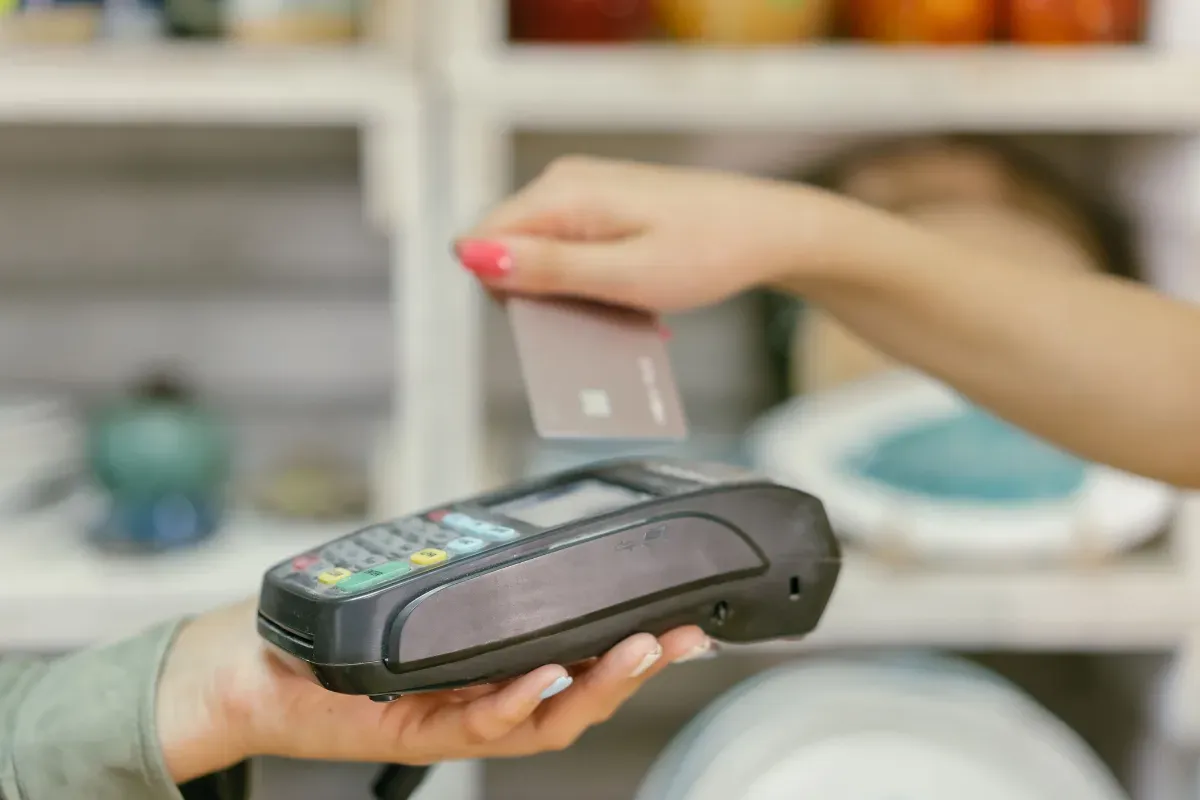 Pessoa usa cartão em terminal de pagamento