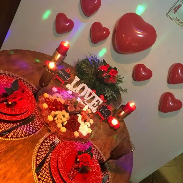 Mesa de madeira com corações e tábuas de frios 