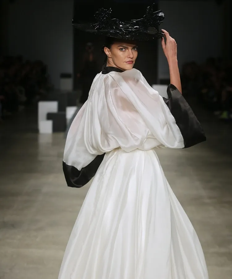 Foto de modelo usando look branco e preto no desfile de chapéus de Davi Ramos no SPFW N60