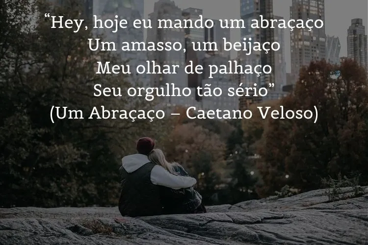 Foto de duas pessoas abraçadas em montanha vendo a cidade e frase: “Hey, hoje eu mando um abraçaço / Um amasso, um beijaço / Meu olhar de palhaço / Seu orgulho tão sério” (Um Abraçaço – Caetano Veloso)