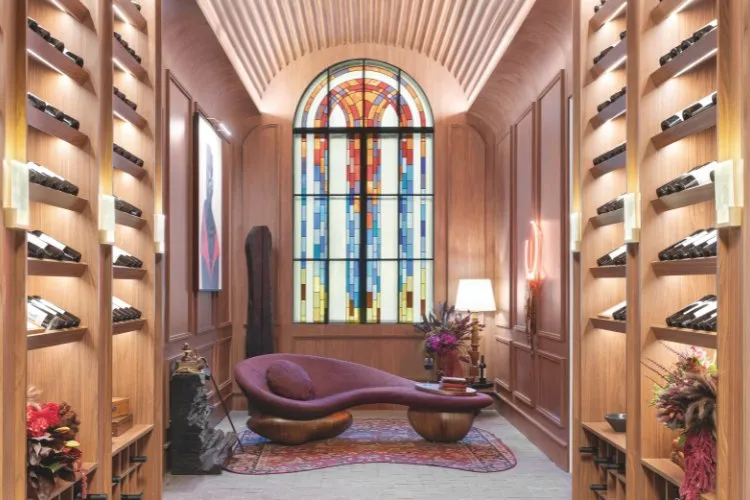 Adega de madeira com divã roxo e vitral colorido