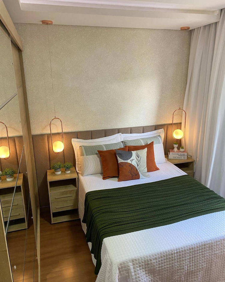 Quarto de casal com luminárias na mesa de cabeceira.