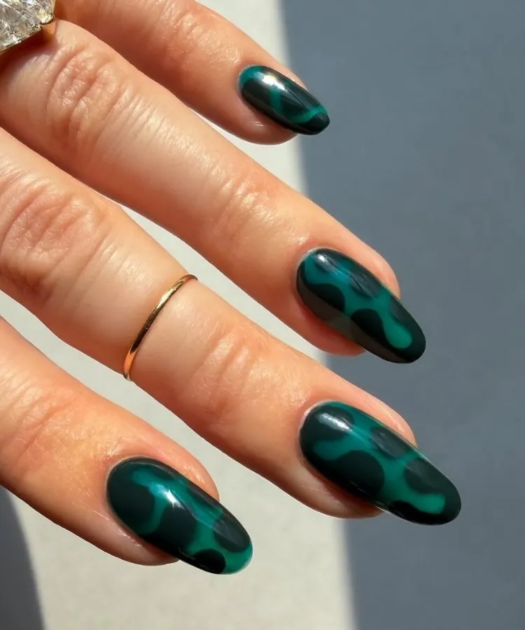 Foto de unhas pintadas com esmalte azul-petróleo, uma das tendências de unhas para 2026